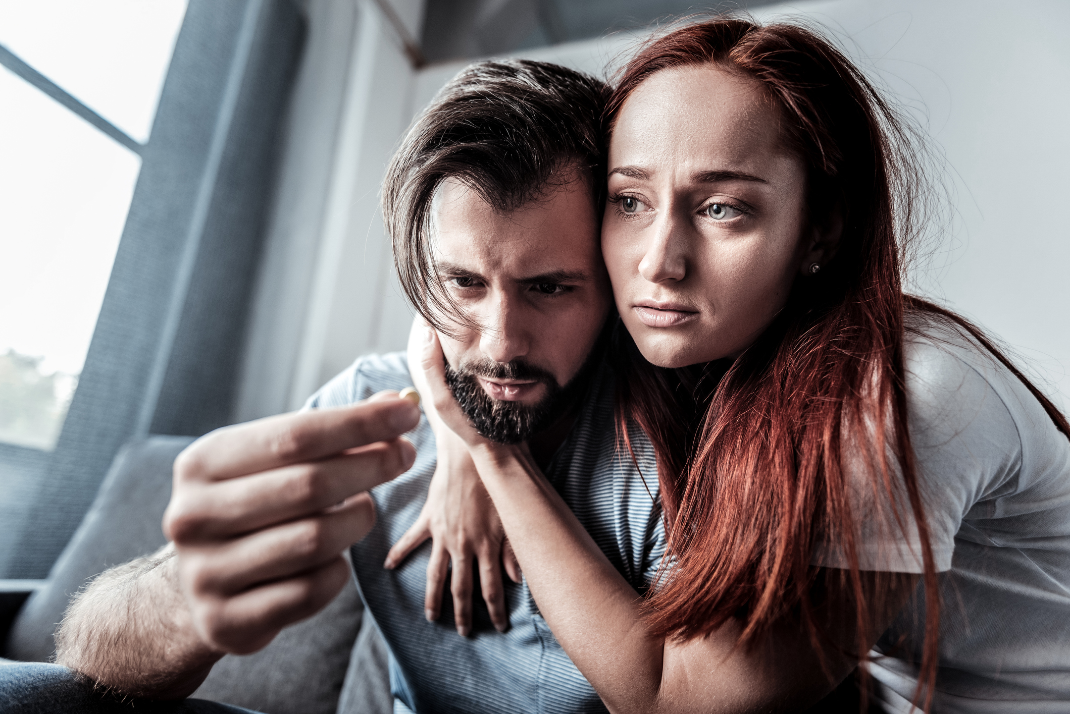 Unhappy depressed young woman sitting together with her boyfriend fighting benzodiazepines addiction